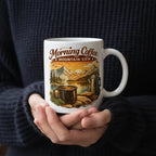 Keramiktasse mit Illustration von Bergen, Sonnenaufgang und dampfender Kaffeetasse im Outdoor-Stil.