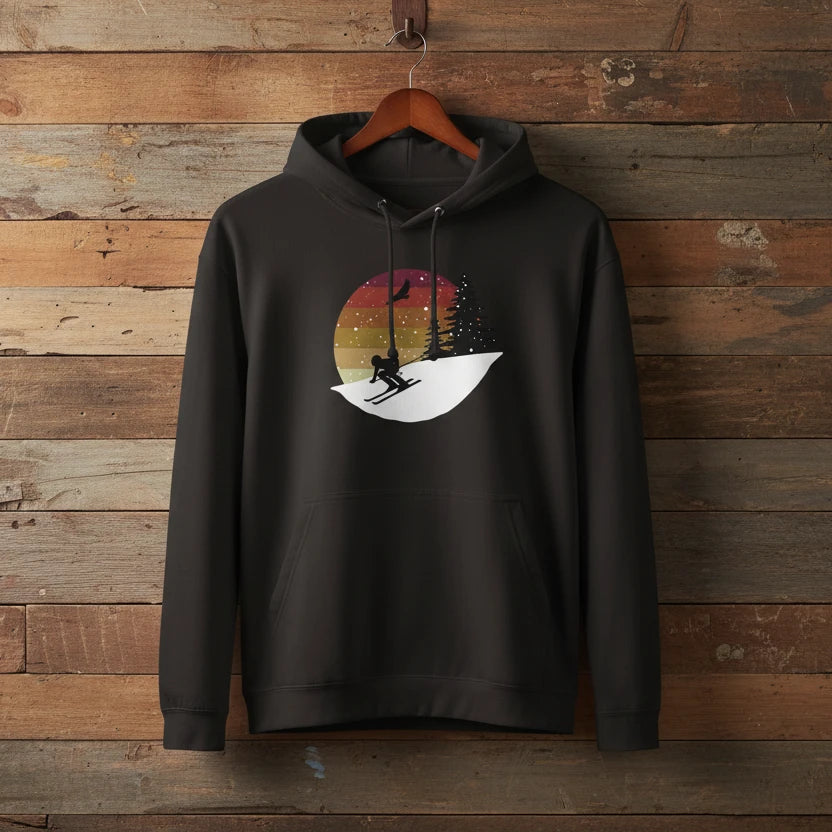 Schwarzer Hoodie mit illustrativem Motiv eines Skifahrers vor winterlicher Landschaft und Sonnenuntergang. Design in Rot oder Grün erhältlich.